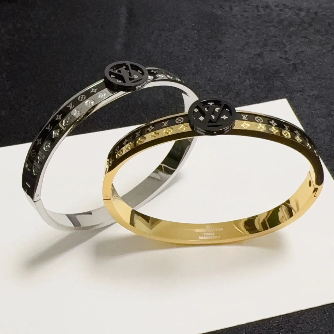 Gold and black designer bangle bracelet on wrist - Hình 3