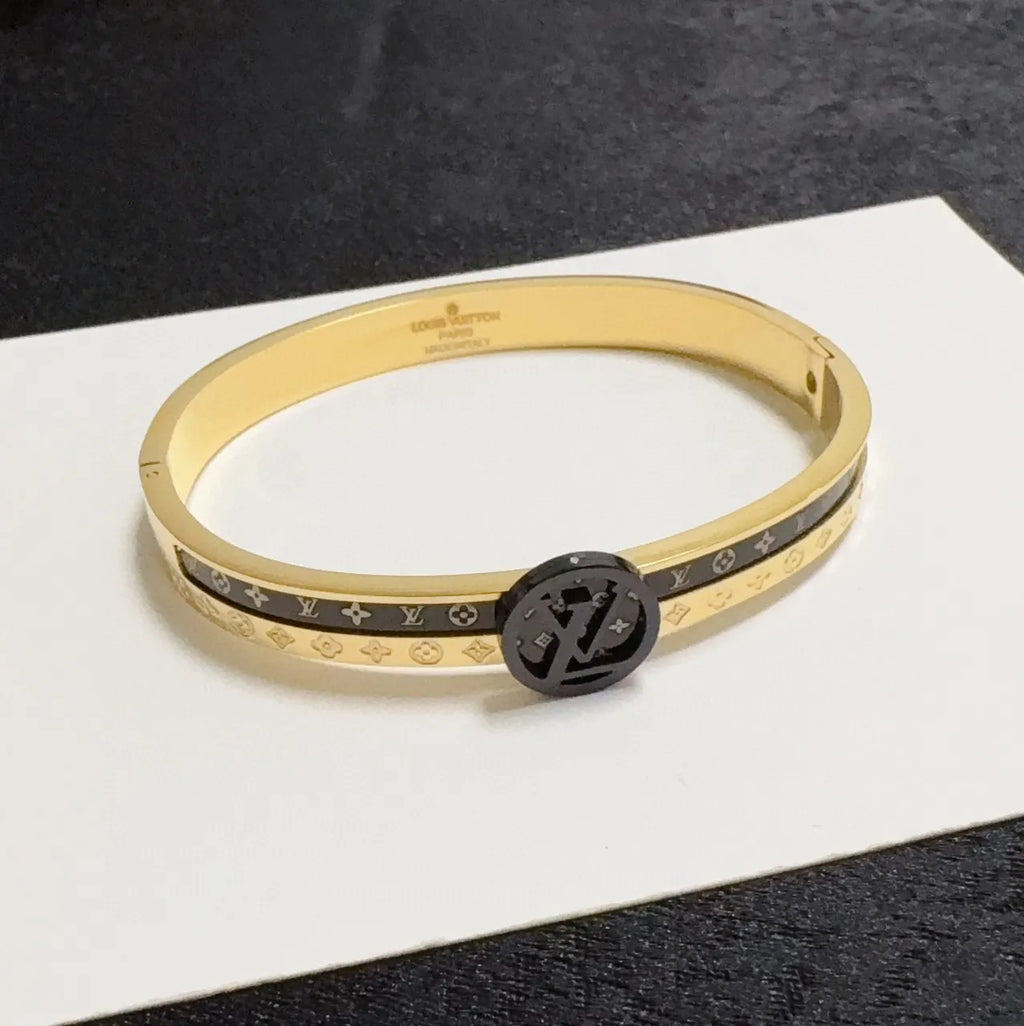 Gold and black designer bangle bracelet on wrist - Hình 4