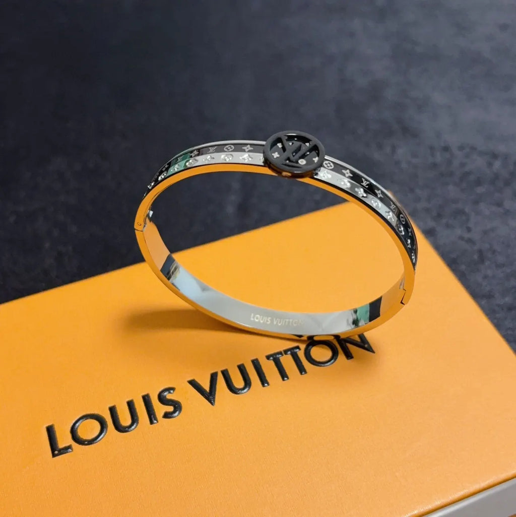 Gold and black designer bangle bracelet on wrist - Hình 5