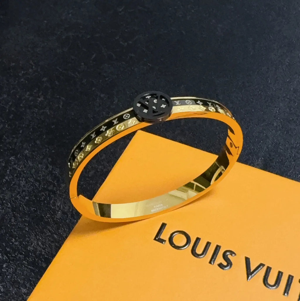 Gold and black designer bangle bracelet on wrist - Hình 6