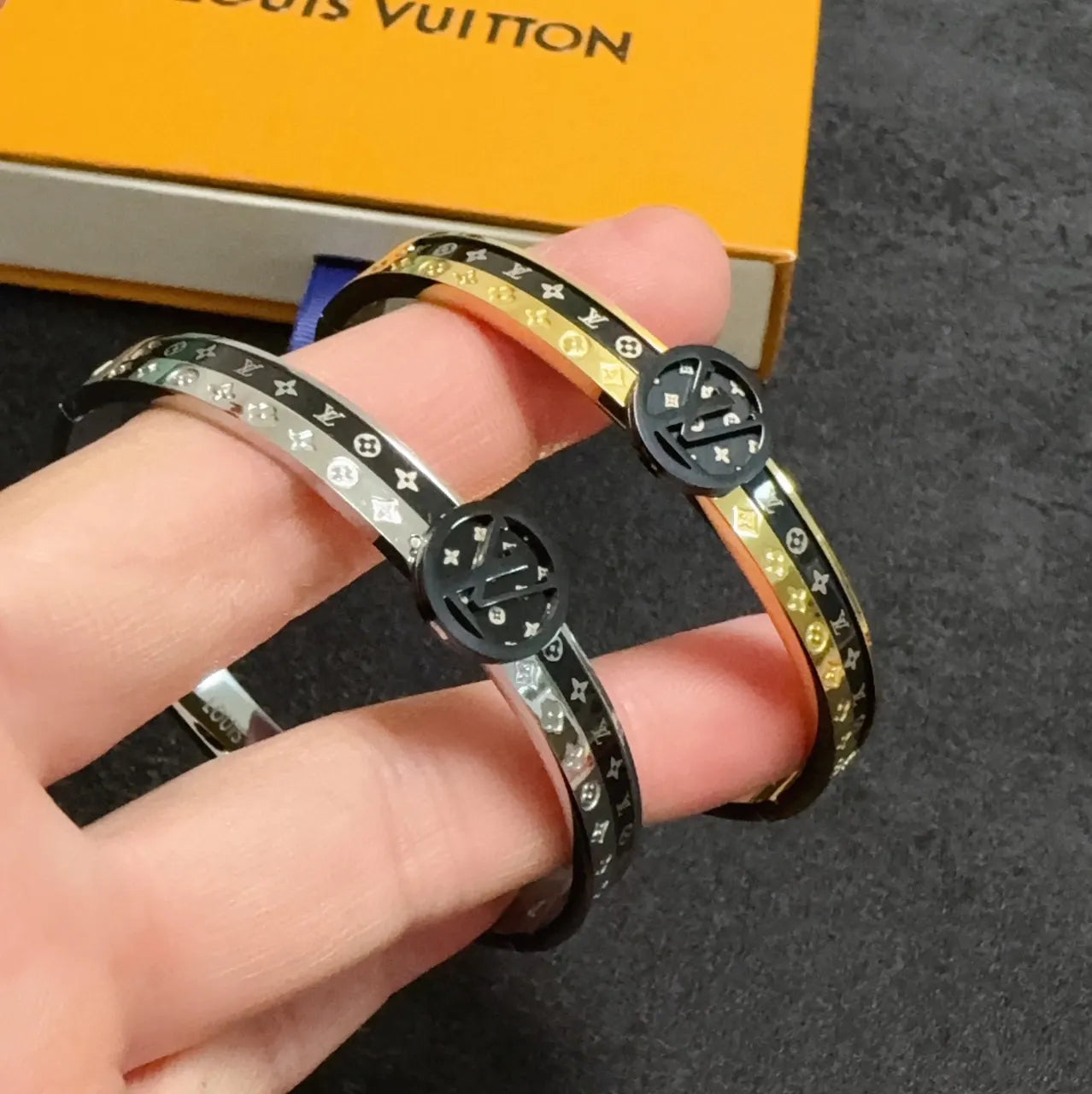 Gold and black designer bangle bracelet on wrist - Hình 8